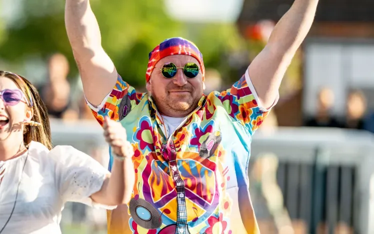A race goer at Lingfield in fancy dress throws his hands in the air