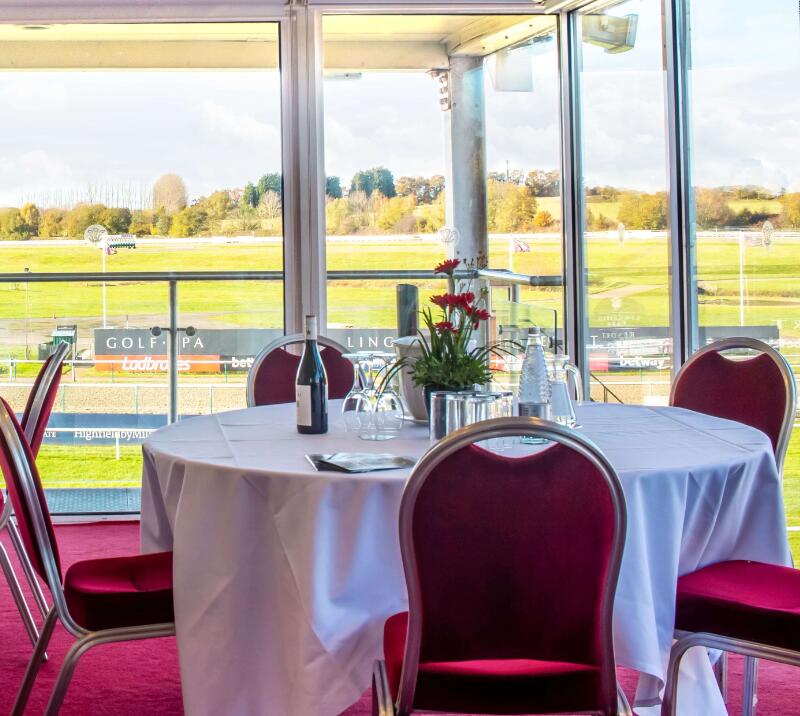 A table in the Director's box at Lingfield Park with the sunny view out over the course.