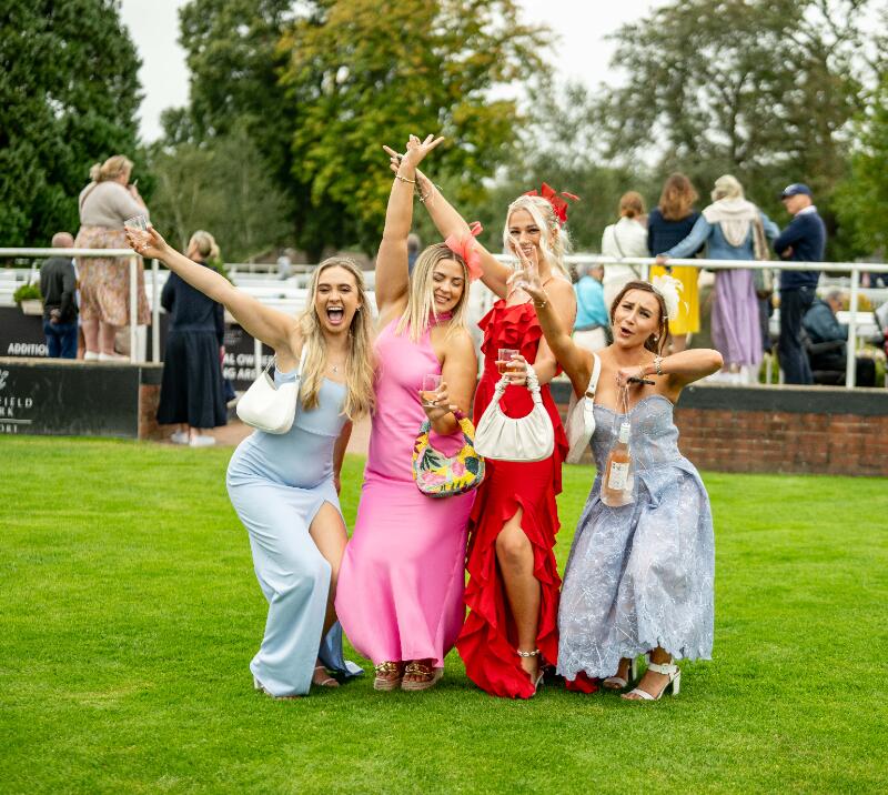A group of young race goers pose on the lawn at Lingfield