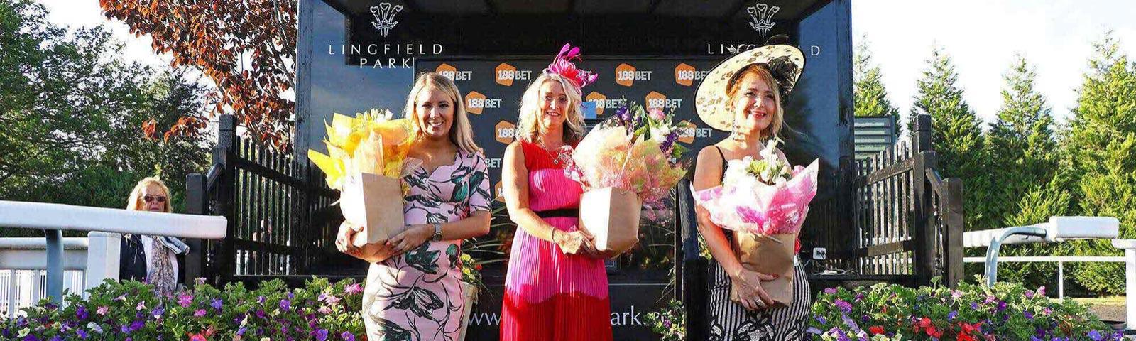 3 Ladies pose with bouquets of flowers.