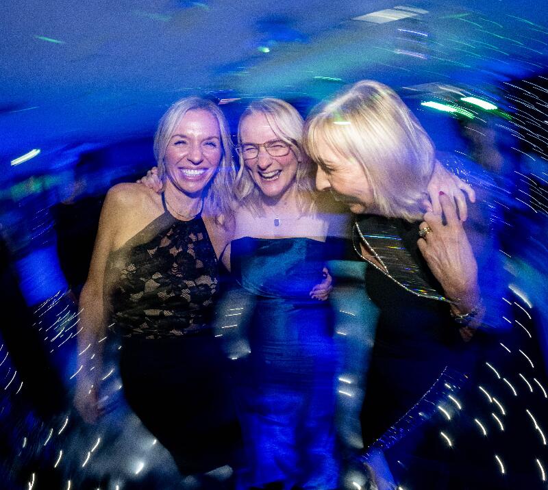 A group of three women laughing, having fun.