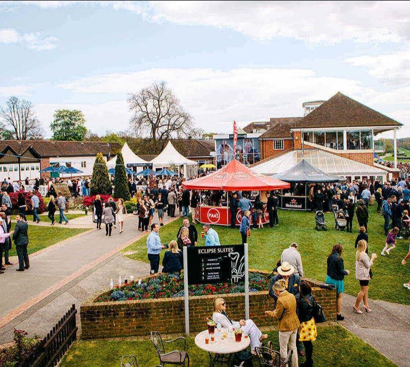 A crowd gathering in the outside space at Lingfield Park Racecourse.
