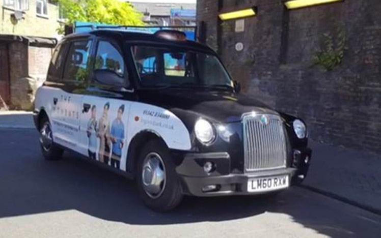 Black cab with wombats advert on its side.
