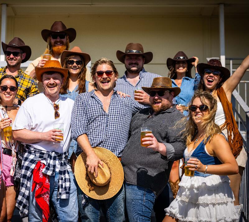 group of men and women cheering in country outfits