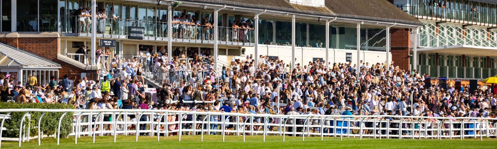 A full crowd in the sunshine in the grandstands at Lingfield Park