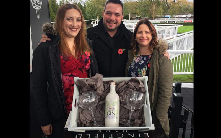 Owners holding a prize box with bottle of gin inside.